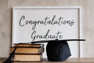 Graduation Cap on Books with Congratulations Sign