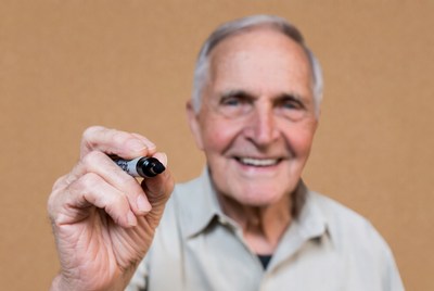 Smiling senior man holding marker