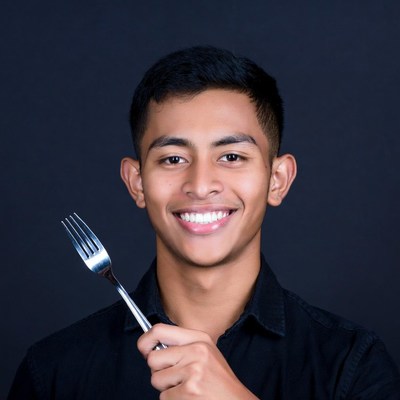 Young Asian man holding fork