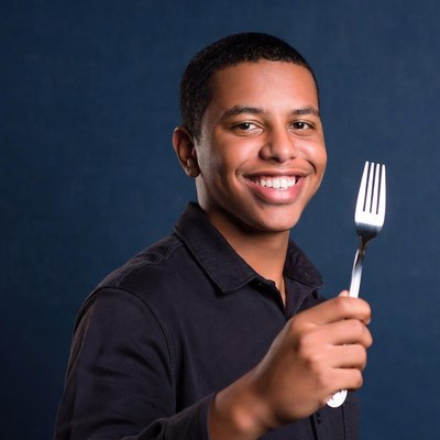Smiling young man holding fork