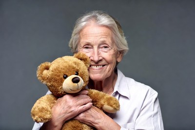 Elderly woman hugging teddy bear