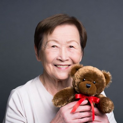 Elderly Asian woman holding teddy bear