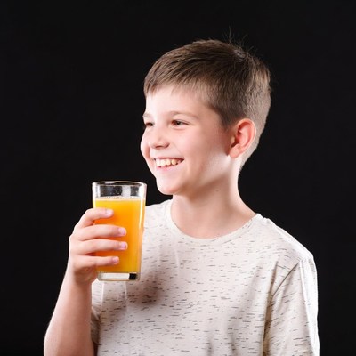 Boy holding glass of orange juice