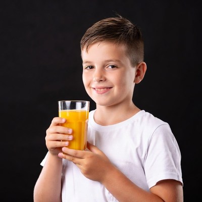 Boy holding glass of orange juice
