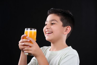 Boy smiling with orange juice glass