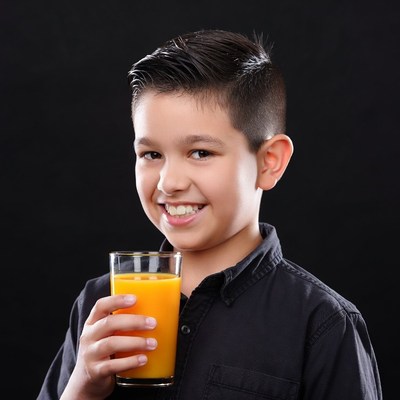 Boy holding glass of orange juice