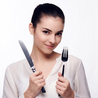 Woman holding knife and fork