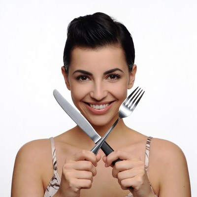 Woman holding crossed knife and fork