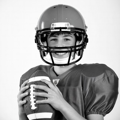 Boy holding football in helmet