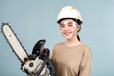 Asian woman holding chainsaw