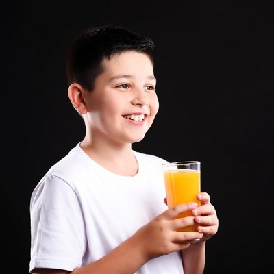 Boy holding glass of orange juice