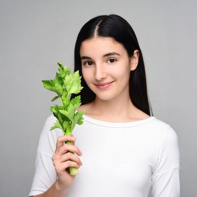 Young woman holding celery