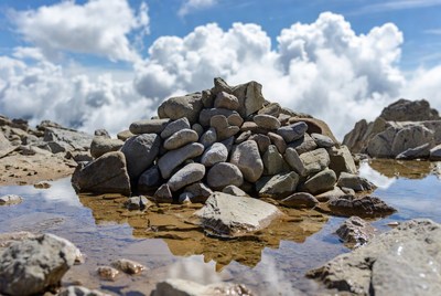 Cairn on mountain peak with reflection