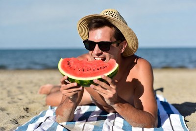 Man eating watermelon on beach