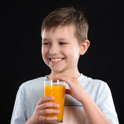 Boy holding glass of orange juice