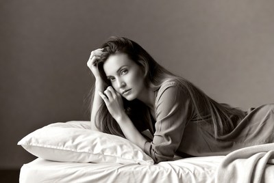 Woman lying pensively on bed