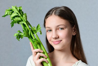 Girl holding fresh celery stalks