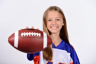 Girl holding football in jersey