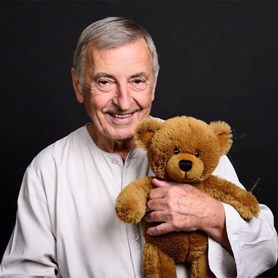 Elderly man holding teddy bear