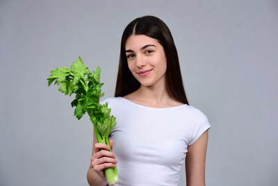 Young woman holding celery