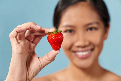 Asian woman holding strawberry