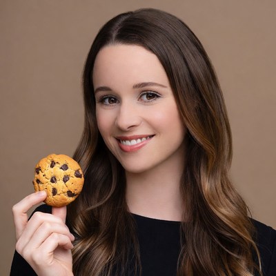 Young woman holding chocolate chip cookie