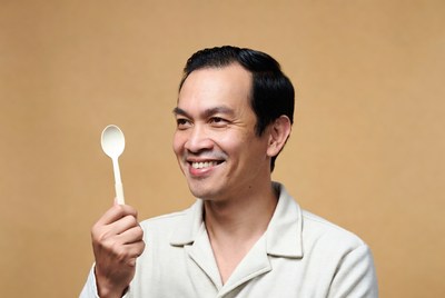 Asian man holding white spoon