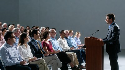 Man speaking at podium to audience