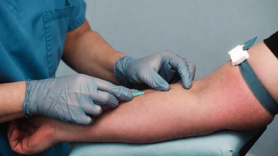 Nurse drawing blood from patient's arm