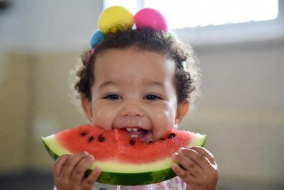 Baby girl eating watermelon slice