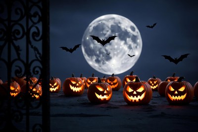 Jack-o'-lanterns under full moon with bats