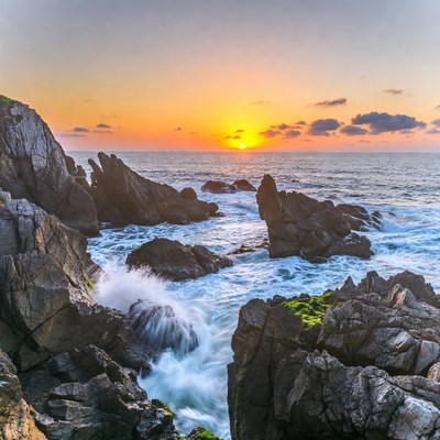 Sunset over rocky ocean waves