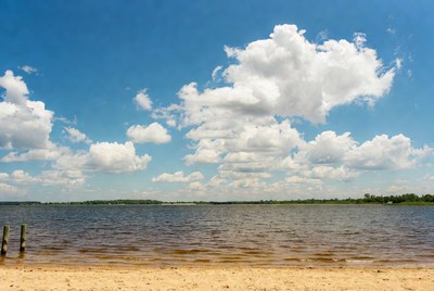 Lake with sandy beach and wooden pilings