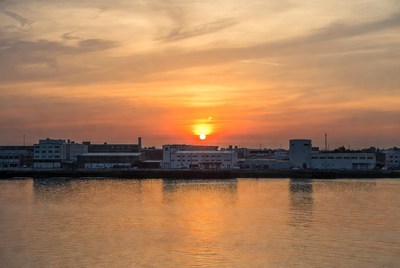 Sunset over industrial waterfront buildings