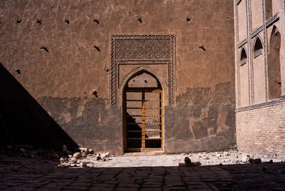 Yellow arched door in ancient mud wall
