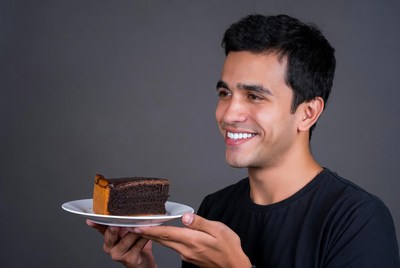 Man holding chocolate cheesecake slice