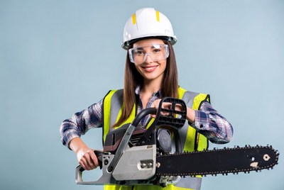 Woman holding chainsaw in safety gear