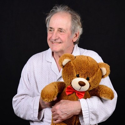 Elderly man holding teddy bear