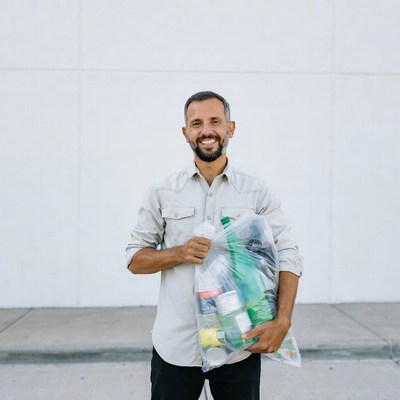 Man holding bag of plastic bottles