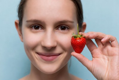 Woman holding fresh strawberry