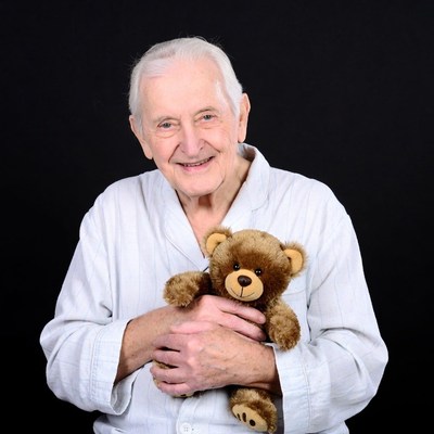 Elderly man holding teddy bear