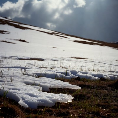 Snowy Hill with Grass and Clouds