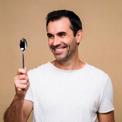 Man holding spoon smiling