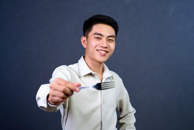 Asian man holding fork