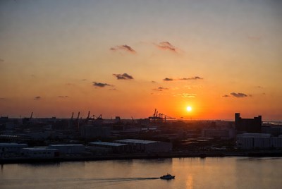Sunset over industrial harbor cranes