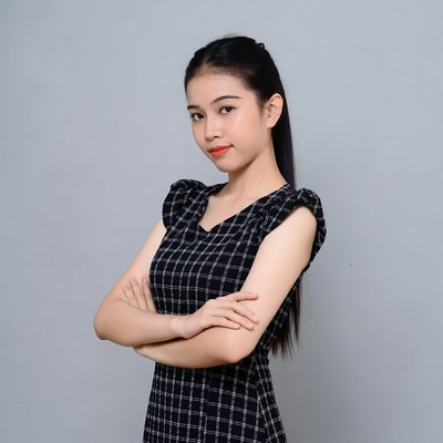 Asian woman arms crossed in plaid dress