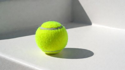Yellow tennis ball on white surface