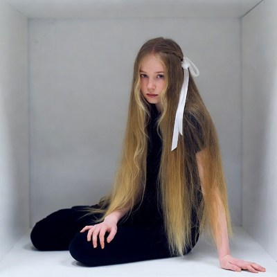 Girl sitting in white box