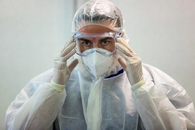 Man adjusting goggles in PPE suit