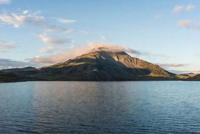 Volcano with Steam over Mountain Lake